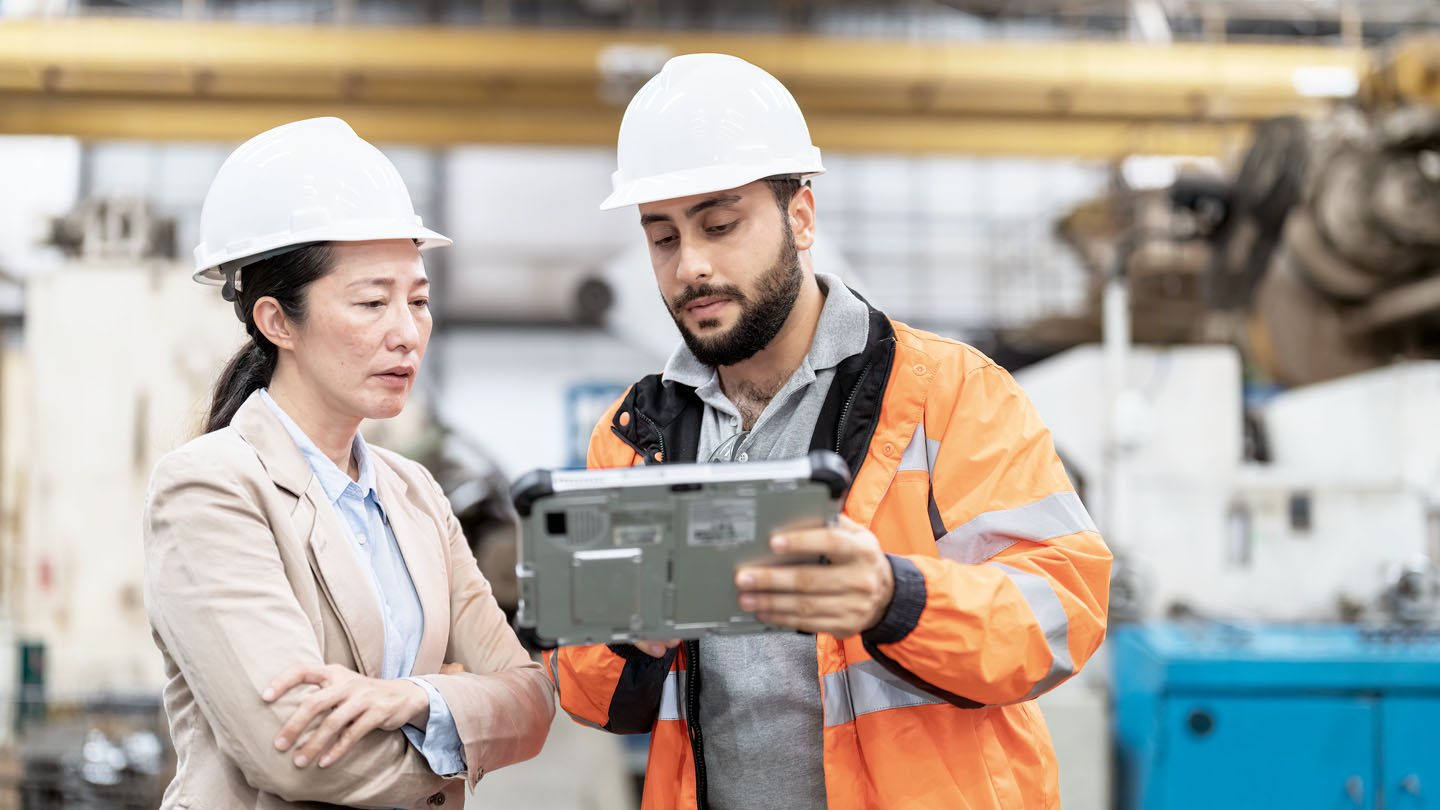 2 workers looking at tablet